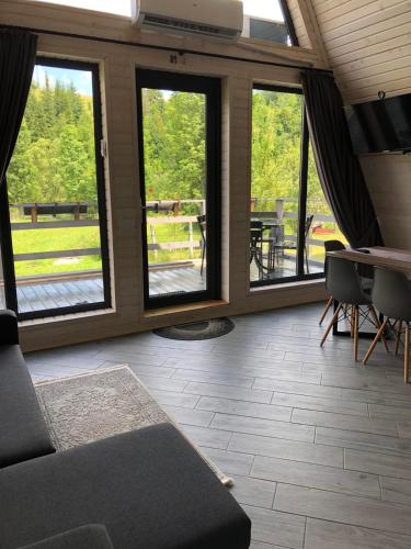 a living room with a couch and a table and windows at Soul House in Pilipets