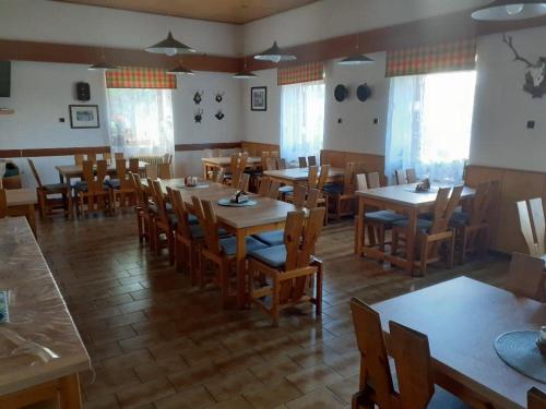 a dining room with wooden tables and chairs at Penzion Kukla in Kuklík