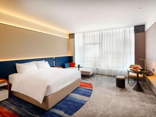 a hotel room with a bed and a large window at Novotel Nanjing Airport in Nanjing