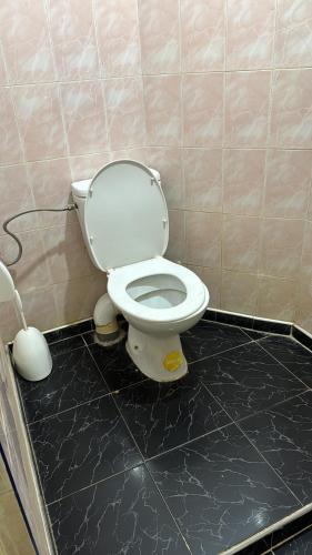 a bathroom with a toilet in a tiled room at Appartement Ayman in Khemisset