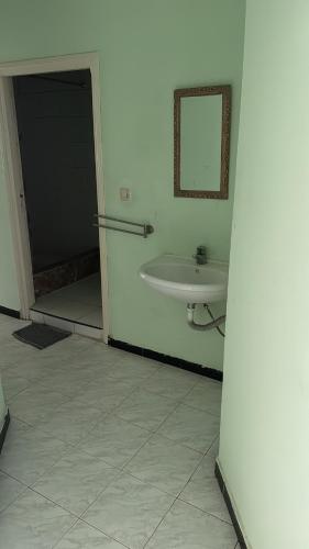 a white bathroom with a sink and a mirror at Appartement Ayman in Khemisset