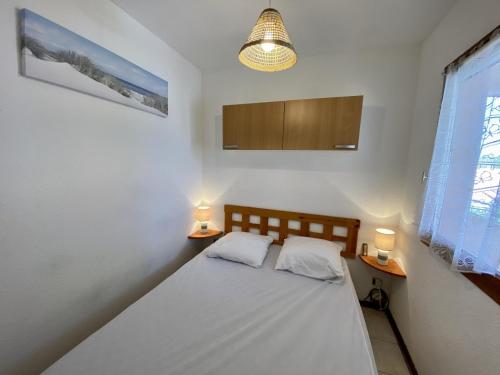 une chambre avec un lit avec deux lampes et une fenêtre dans l'établissement Appartement T2 Cabine - Parking - Piscine - 6 Personnes - FR-1-795-4, à Fleury