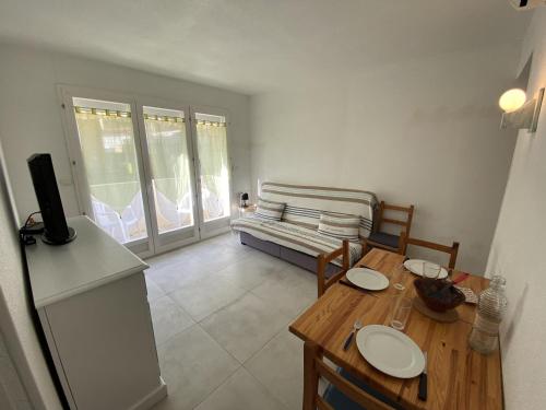un salon avec une table et un canapé dans l'établissement Narbonne-Plage : T2 climatisé, balcon, parking, à 100m de la plage, commerces à proximité - FR-1-795-12, à Narbonne