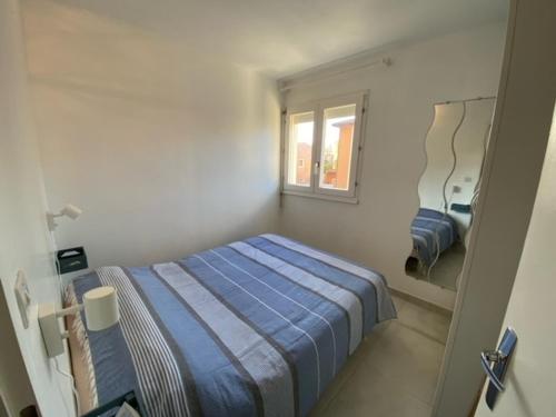 une petite chambre avec un lit et une fenêtre dans l'établissement Narbonne-Plage : T2 climatisé, balcon, parking, à 100m de la plage, commerces à proximité - FR-1-795-12, à Narbonne