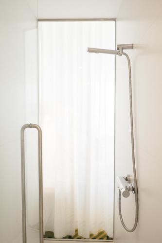a shower in a bathroom with a shower curtain at Macarico Beach Hotel in Praia de Mira