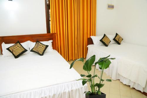 two beds with pillows on them in a room at Bella Vista Villa in Seeduwa