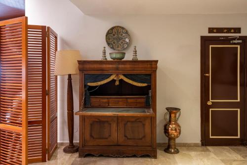 a room with a wooden cabinet and a lamp at Parador de Melilla in Melilla