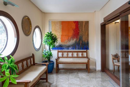 a living room with a bench and a painting at Parador de Melilla in Melilla