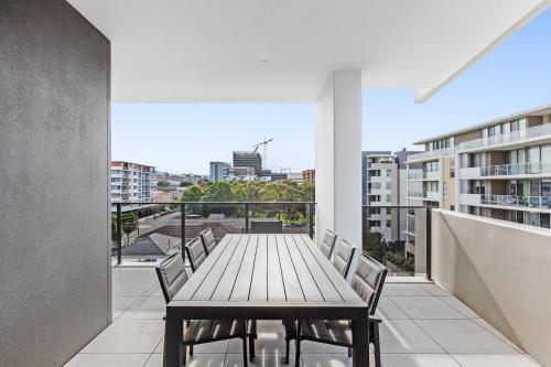 a table on a balcony with a view of a city at Astra Apartments Wollongong Beatson Street in Wollongong