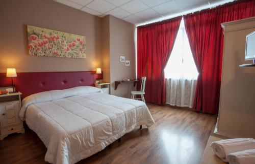 sypialnia z dużym łóżkiem i czerwonymi zasłonami w obiekcie Ankon Hotel w mieście Ancona