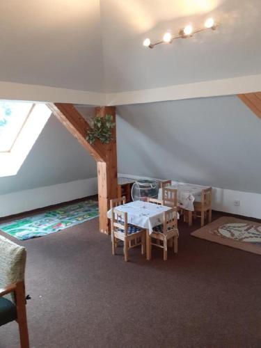 a room with a table and chairs in a attic at Penzion Kukla in Kuklík
