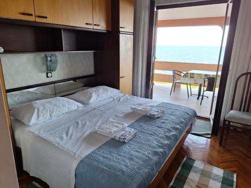 une chambre avec un lit avec vue sur l'océan dans l'établissement Apartman Ksenija, à Lun