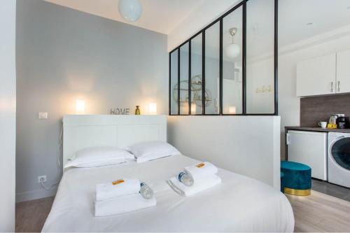 - une chambre avec un lit blanc et trois oreillers dans l'établissement Great Studio Paris 16, à Paris