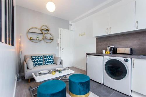 un salon avec une machine à laver et des tabourets bleus dans l'établissement Great Studio Paris 16, à Paris