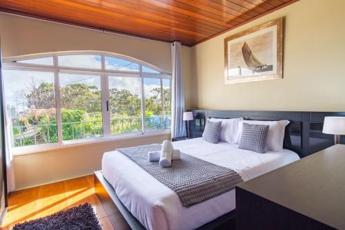 una camera da letto con un letto e una grande finestra di GuestReady - Quinta das Estrelas a Campanário
