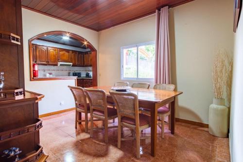 a kitchen and dining room with a wooden table and chairs at GuestReady - Quinta das Estrelas in Campanário