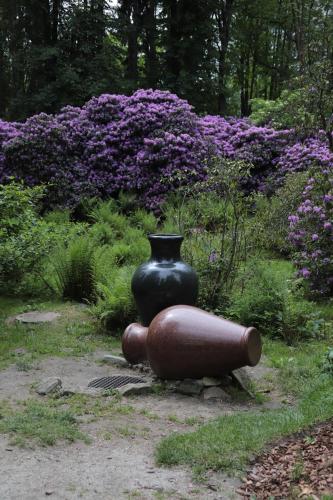 a vase sitting on top of a statue in a garden at Jasny Dwór in Polanica-Zdrój