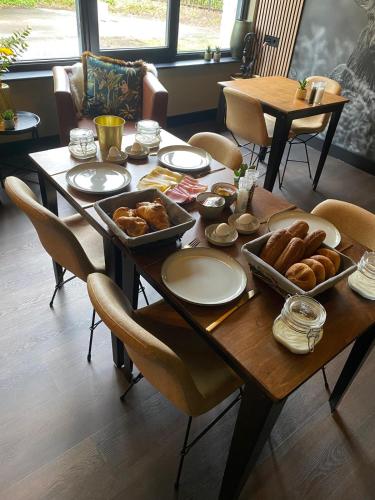 - une table en bois avec du pain et des viennoiseries dans l'établissement The Lodge, à Best