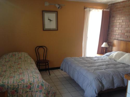 a bedroom with a bed and a chair and a window at Aparthotel San Francisco in Santiago