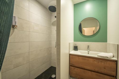 une salle de bain avec un lavabo et une douche avec un miroir dans l'établissement OIQIA • Solis • Azur, à Narbonne