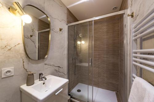 une salle de bain avec une douche, un lavabo et un miroir dans l'établissement L'absinthe AIL, à Villeurbanne