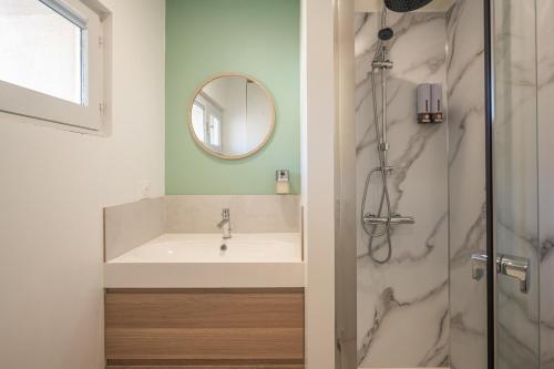 une salle de bain avec un lavabo et une douche dans l'établissement OIQIA • Solis • Opaline, à Narbonne