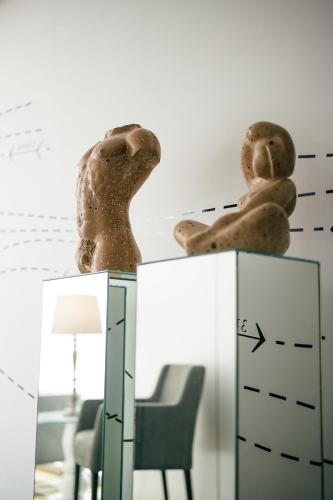 a mirror with a statue on top of a dresser at Macarico Beach Hotel in Praia de Mira