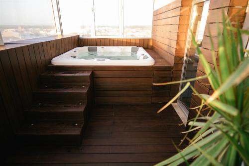 a jacuzzi tub in a bathroom with a window at Macarico Beach Hotel in Praia de Mira