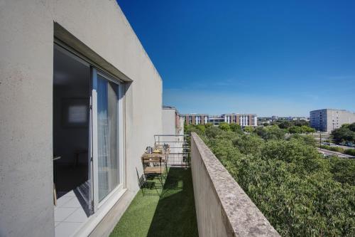 un balcon avec vue sur une ville dans l'établissement La Palm Room ~ Climatisation ~ Balcon ~ Parking, à Nîmes