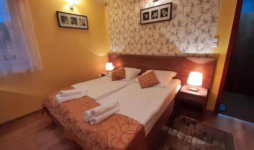 a bedroom with a bed with two towels on it at Pensjonat Zielone Wzgórze w Bolesławowie in Stronie Śląskie