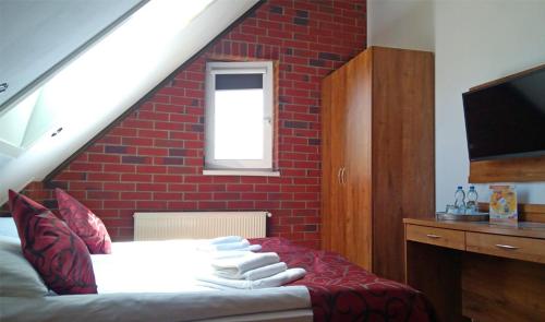 a bedroom with a bed with a red brick wall at Pensjonat Zielone Wzgórze w Bolesławowie in Stronie Śląskie