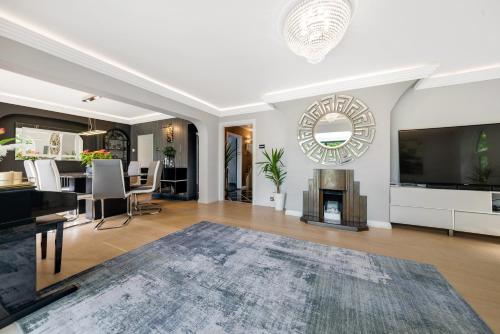 a living room with a fireplace and a television at Gatsby Villa with large garden and fancy hot tub in Chislehurst