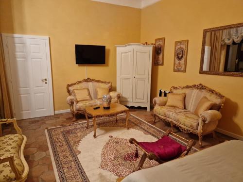 a living room with two chairs and a tv at Appartamenti INCORONATA in Lodi