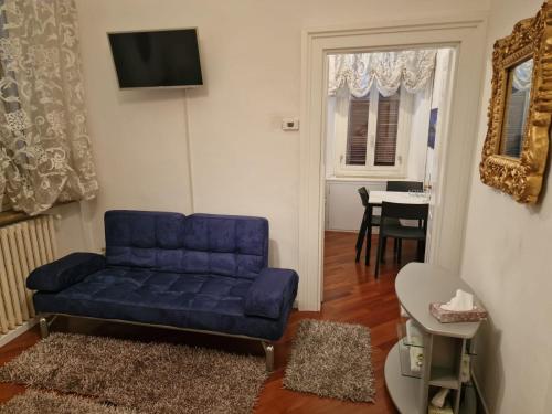 a living room with a blue couch and a table at Appartamenti INCORONATA in Lodi
