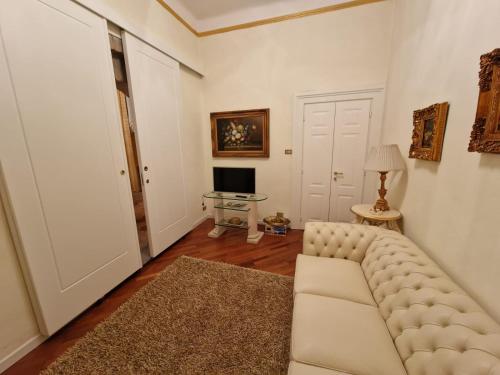 a living room with a white couch and a television at Appartamenti INCORONATA in Lodi