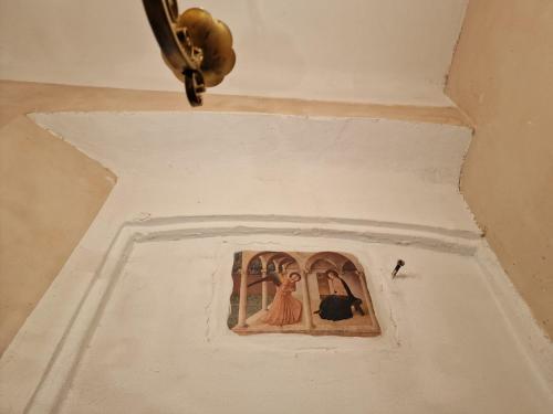 a painting of two women in a window on a wall at Appartamenti INCORONATA in Lodi