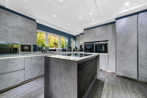 an open kitchen with a large island in the middle at Gatsby Villa with large garden and fancy hot tub in Chislehurst