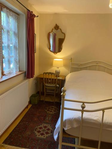 una camera da letto con un letto, un tavolo e uno specchio di Hillside Launceston Cornwall a Launceston