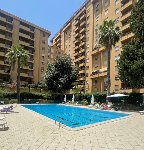 a swimming pool in front of two large buildings at Sara House Palermo in Palermo