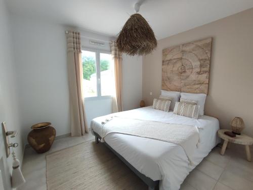 une chambre avec un lit blanc et une grande fenêtre dans l'établissement Maison de vacances, cosy, bohème chic, avec jardin!, à Bois-de-Cené