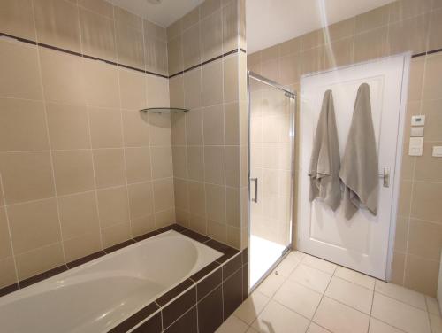 une salle de bain avec baignoire et douche dans l'établissement Maison de vacances, cosy, bohème chic, avec jardin!, à Bois-de-Cené