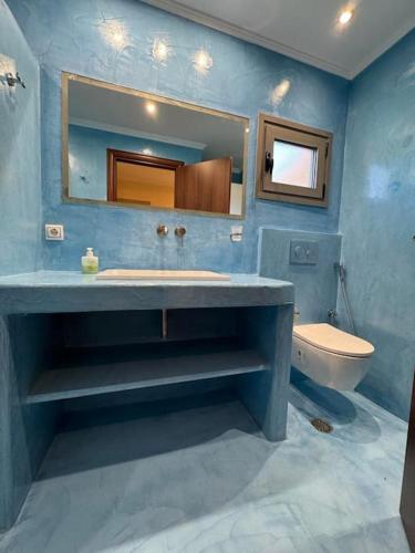 a blue bathroom with a sink and a toilet at Villa Bournous in Mesokhória