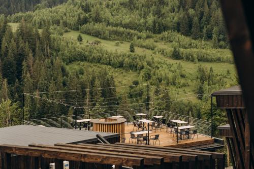a deck with tables and chairs on top of a mountain at Mandra Morion in Ogrody