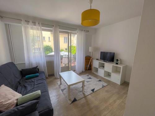 un salon avec un canapé et une table dans l'établissement Chez Chris, studio cosy hypercentre, à Strasbourg