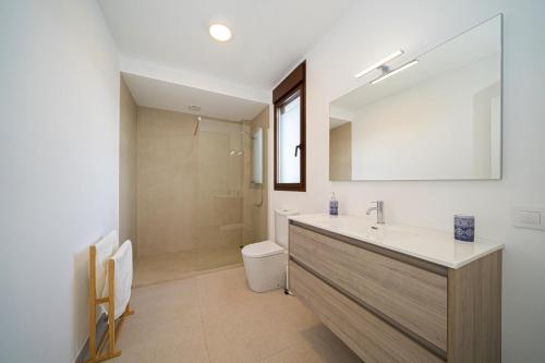 ein Badezimmer mit Waschbecken, Toilette und Spiegel in der Unterkunft LA CALMA - Managed by Almarina in Moraira