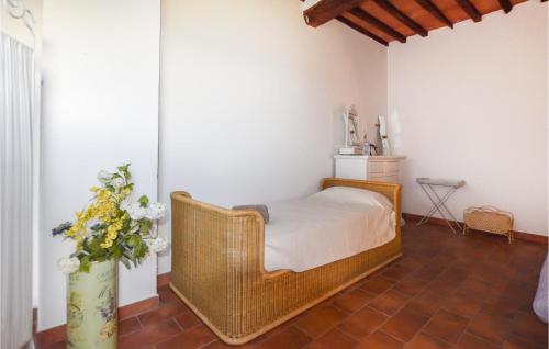 a bedroom with a wicker bed and a vase of flowers at Stunning Home In Monterotondo Marittimo in Monterotondo