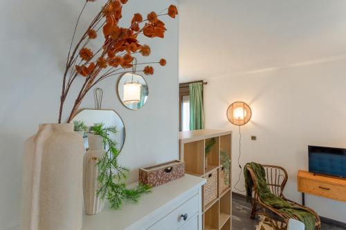 - un salon avec un vase orné de fleurs dans l'établissement Le Baudis - Grand Studio avec coin nuit et parking, à Toulouse