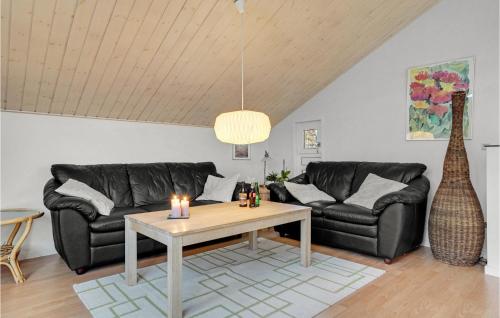 a living room with two black leather couches and a table at 2 Bedroom Lovely Home In Aabenraa in Aabenraa
