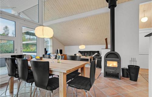 a dining room with a table and a wood stove at 2 Bedroom Lovely Home In Aabenraa in Aabenraa