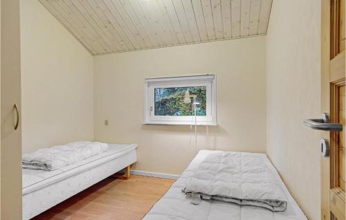 two beds in a room with a window at 2 Bedroom Lovely Home In Aabenraa in Aabenraa